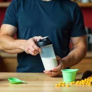 «آماده‌سازی شیک پروتئینی با شیکر ورزشی؛ تصویری مرتبط با اینکه پودر کراتین مونوهیدرات چیست و برای چه کسانی مناسب است»