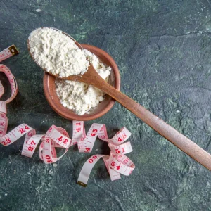 «پودر کربوهیدرات در قاشق به‌همراه متر اندازه‌گیری؛ تصویری مرتبط با کربو انرژی به‌عنوان بهترین مکمل برای افزایش وزن سالم»